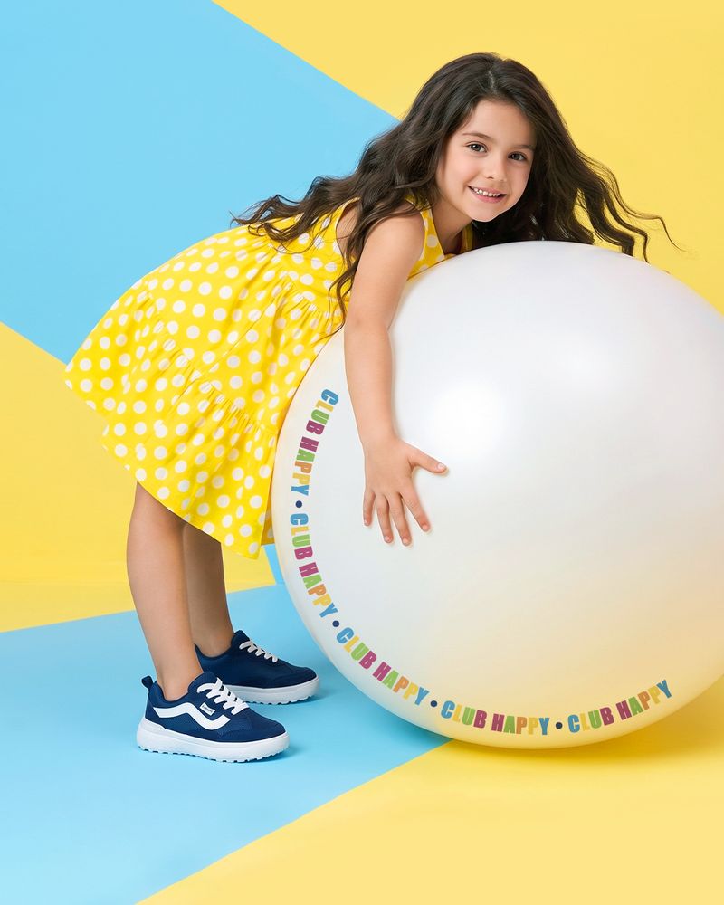 Menina sorrindo abraçada a uma bola gigante