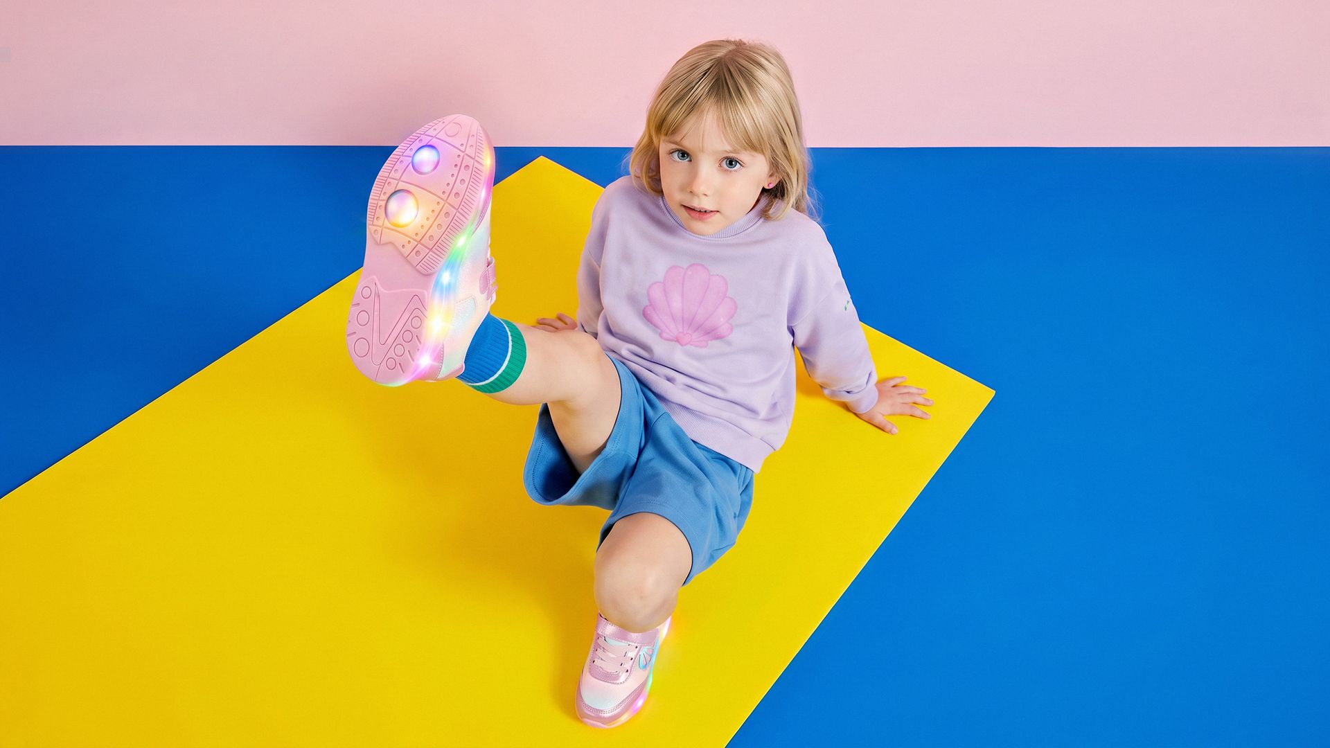 Menina sentada mostrando o tênis com LED aceso